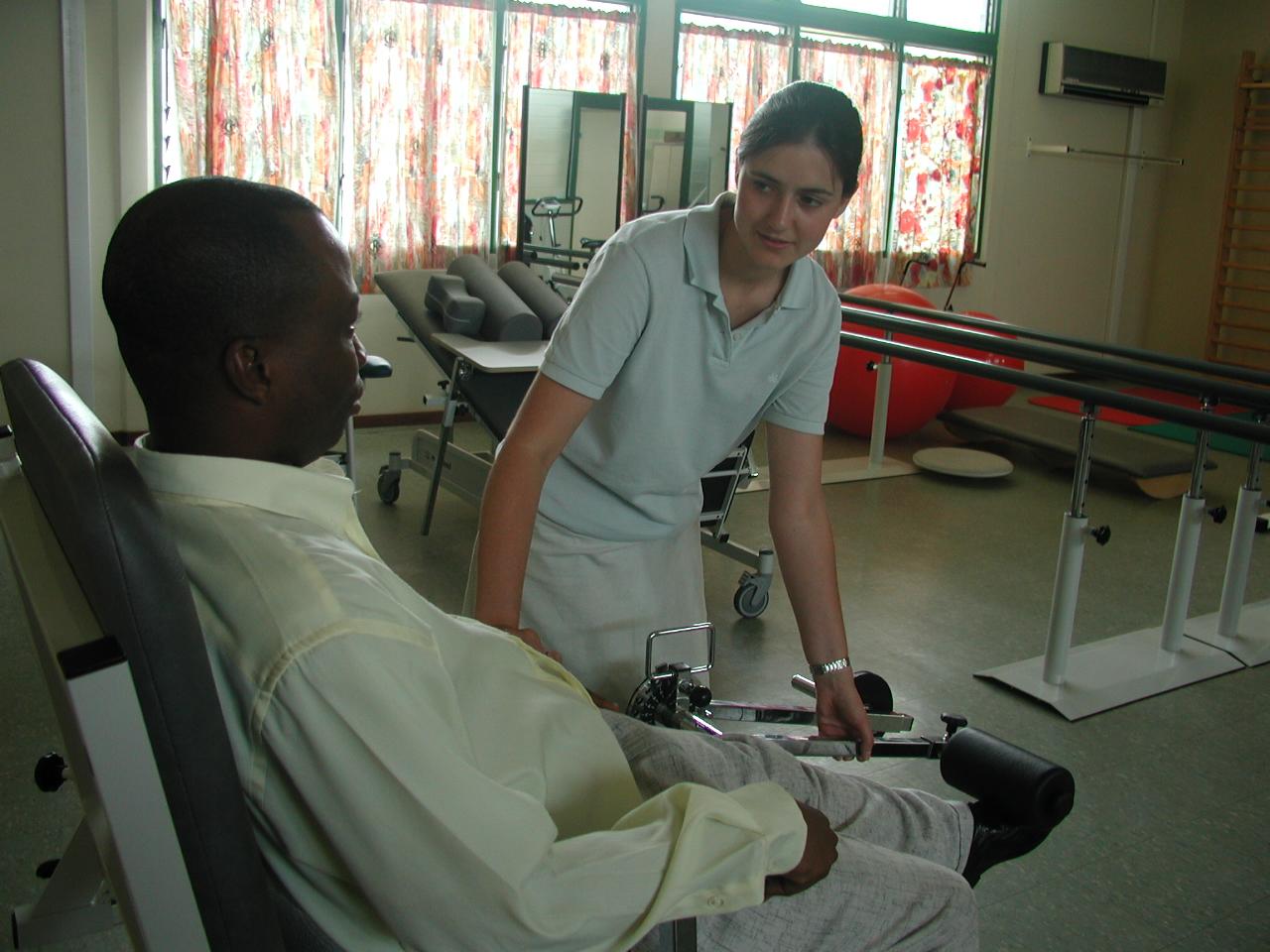 Projects Abroad intern assisting a man stretch whilst on her physiotherapy internship in Ghana. An intern from Projects Abroad is pictured helping a man stretch as part of her physiotherapy internship in Ghana.